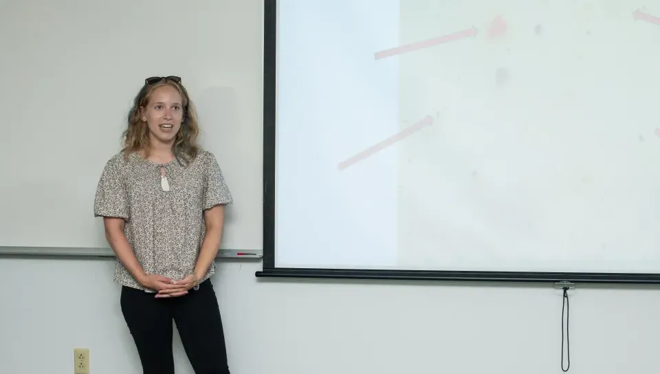 A UNE student presents her research on a slideshow